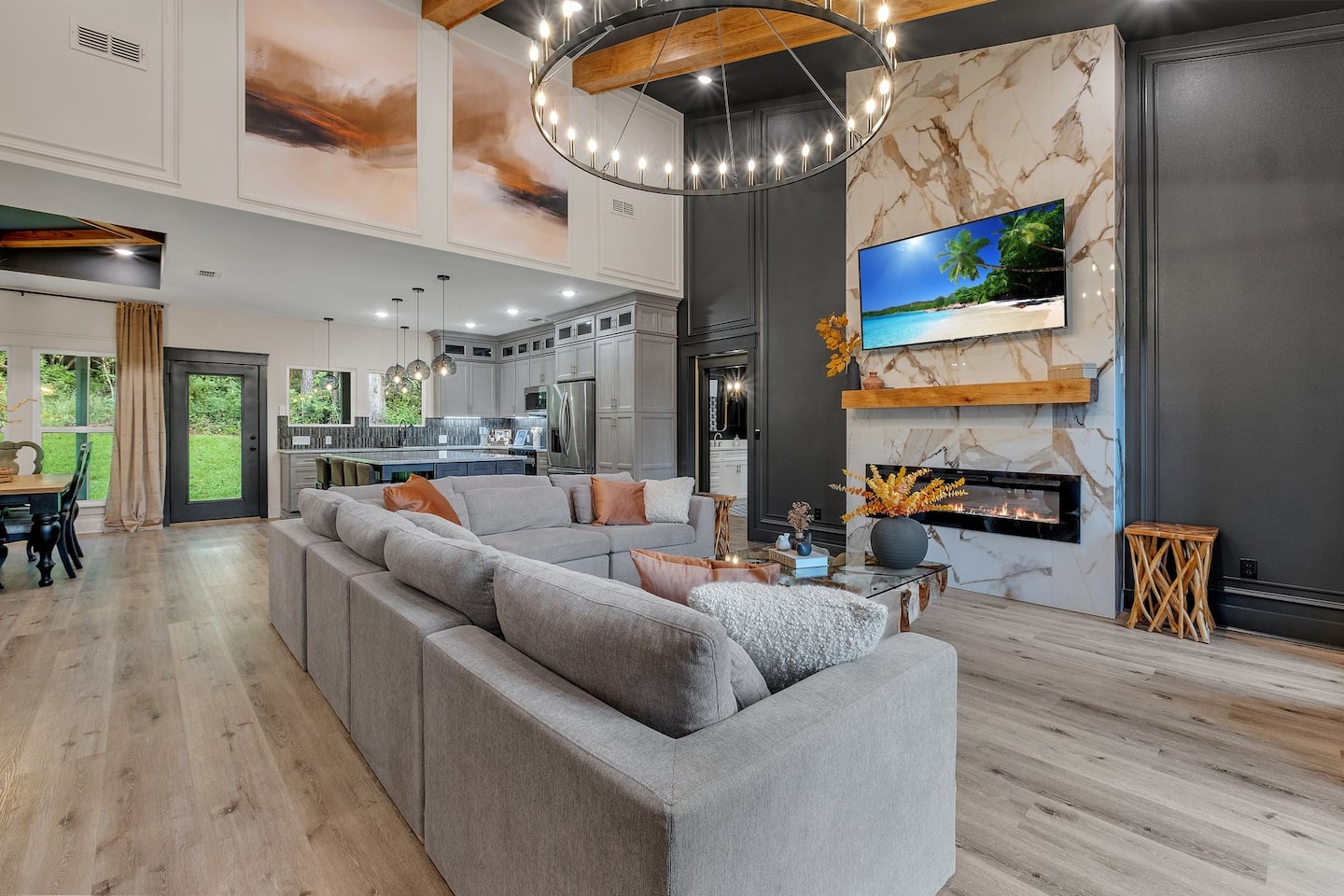 The living room at Luxe — marble fireplace, soaring ceilings and a chandelier